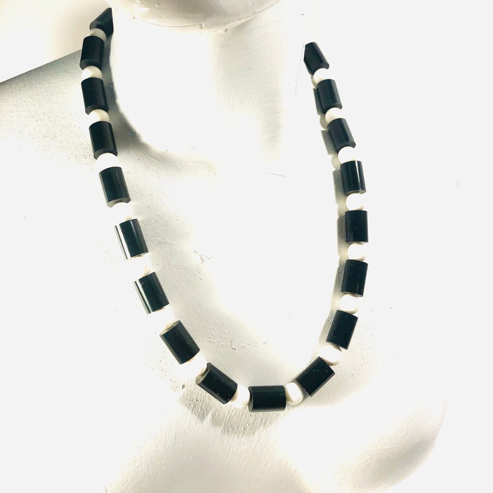 It’s 60’s mod Vintage and plastic acrylic material.  Black and white.